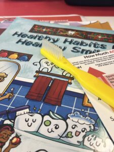 Supplies from the Oral Health Story Kit includes a tooth brush and educational materials