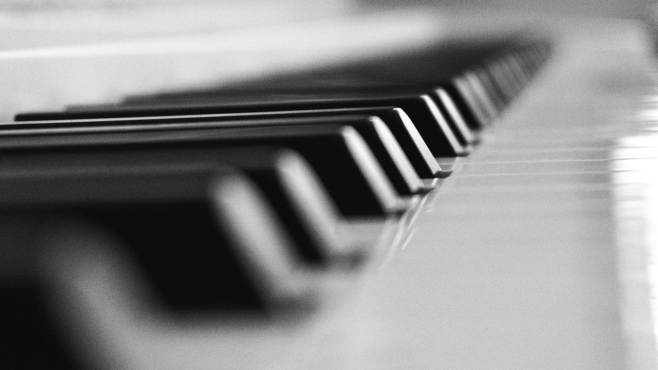 Artistic black and white close-up of piano keys in soft focus, emphasizing musical elegance.
